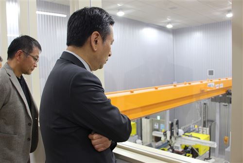 (3)リサイクル工場で再資源化されたペレットを素材として容器を製造する工程を見学する知事と杉山社長。