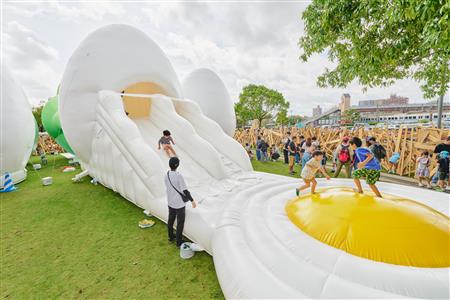 たまごの中のすべり台で遊ぶこどもたち