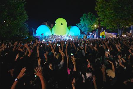 夜の音楽ステージで盛り上がる観客とライトアップされたネストピアン