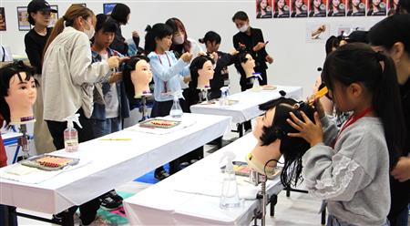 美容師の仕事（ヘアアレンジ）に励むこどもたち
