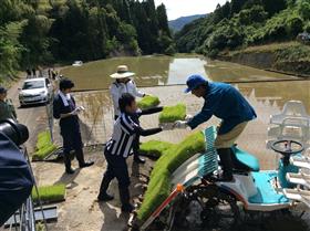 田植え作業の手伝いを行っている様子（平野の棚田地域住民と株式会社プライム会社員）