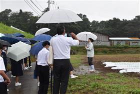 タマネギ圃場で説明を受ける生徒たち