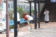 地域の方やたくさんの小学生と一緒に江北駅の清掃をする様子1枚目
