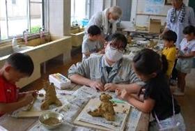 小学生の作陶のお手伝いをしている様子2枚目